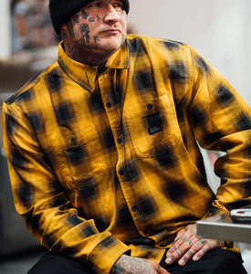 tattooed man in yellow and black plaid shirt 